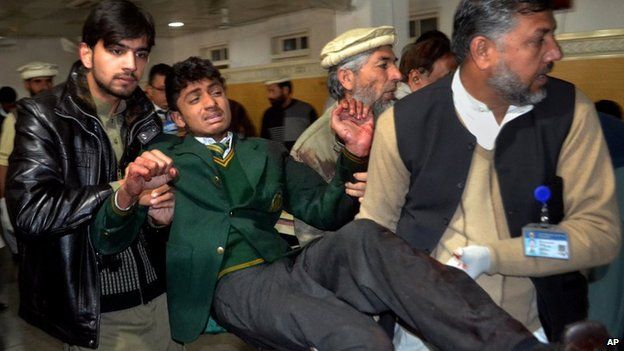 A student is helped after a gun attack at a school in Peshawar