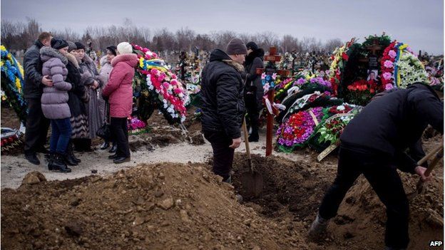 Relatives dig graves in Mariupol, 26 January 2015