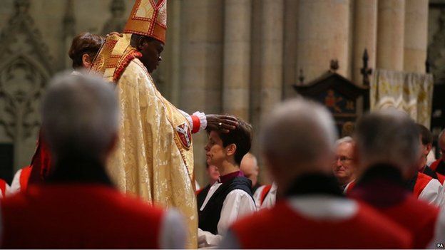 The Rev Libby Lane kneels before the Archbishop of York