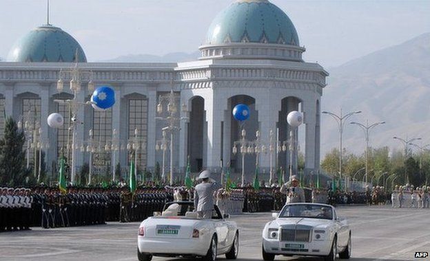 Officials in white cars at a military parade in Ashgabat