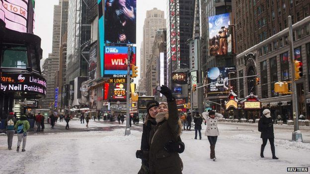 A woman takes a photograph of herself in New York's Times square (27 January 2015)