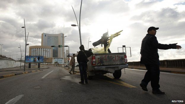 A vehicle belonging to the security forces is pictured near Corinthia hotel (rear) in Tripoli (27 January 2015)