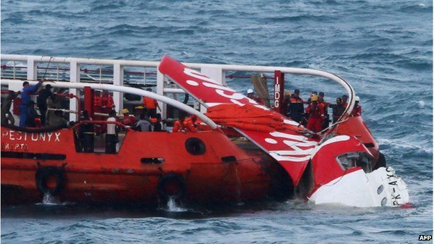 In this file photograph taken on 10 January 2015, Indonesian search and rescue personnel pull wreckage of AirAsia flight QZ8501 onto the Crest Onyx ship at sea.