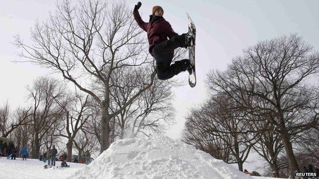 Mason Gloudeman, 26, uses a snowboard to jump from a pile of snow in Fort Greene Park in Brooklyn after a snow storm in New York on 27 January 2015.