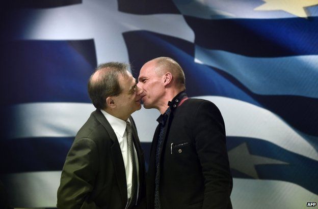 Finance Minister Yanis Varoufakis (R) greets outgoing Finance Minister Gikas Hardouvelis in Athens, 28 January
