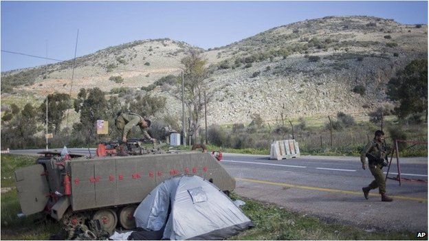 Israeli soldiers guard a road where a missile fired by the Lebanese Hezbollah group struck an Israeli military convoy on Wednesday.