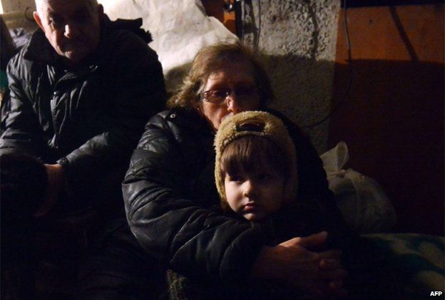 People wait in a shelter for the end of a shelling in Enakieve, south-western Debaltseve on 29 January 2015