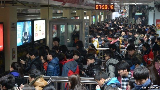 People wait for a subway at Sihui East Station during the first weekday after the subway adopted a new fare policy on 29 December 2014 in Beijing, China