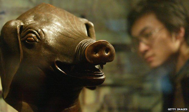 A man views the pig bronze head of Qing Dynasty (1644-1911) at a special exhibition April 28, 2005 in Shenyang of Liaoning Province, China. Four pieces of famous bronze heads including a tiger, a pig, an ox and a monkey of Qing Dynasty art treasure make their debut in Shenyang during the exhibition. They are among the 12 Chinese zodiac sculptures which originally placed in the Old Summer Palace in Beijing. The bronze set were taken out of the country in 1860 by British and French archaeologists. In 2000, the Beijing-based Poly Group bought the heads of the ox, tiger and monkey for more than RMB 30 million (USD 3.66 million) at an auction and returned them to the Chinese mainland. The pig head returned to China after it was purchased from the United States by Macao magnate Stanley Ho for RMB 6 million (USD 720,000) in 2003.