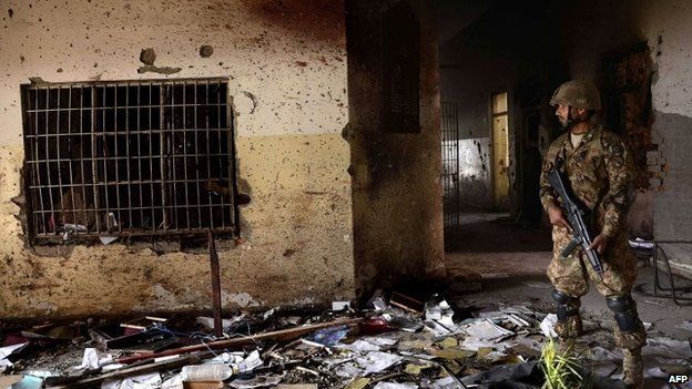In this photograph taken on December 18, 2014, a Pakistani army soldier stands guard at the site of a militant attack on an army-run school in Peshawar. Schools in Pakistan"s north-western city of Peshawar reopened on January 12, 2015