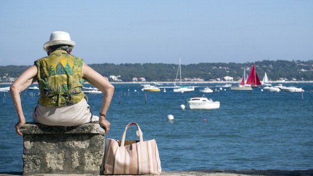 Elderly woman sits by the sea in SW France
