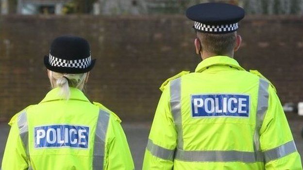 Male and female police officer in high vis jackets