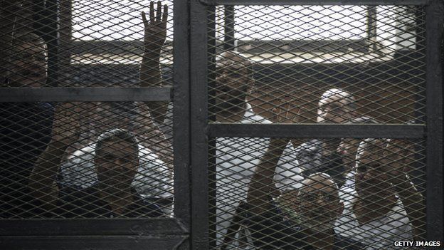 Egyptian Muslim Brotherhood leader Mohamed Badie (2nd right) and other defendants gesture during their trial in Cairo on 7 June 2014