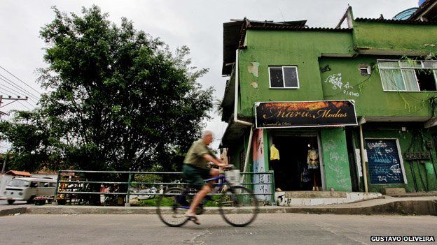 A man cycles past a shop in Vila Uniao in January 2015