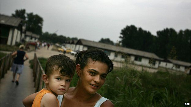 File photo: A Serb woman, a refugee from Croatia, carries her son in a refugee camp near Belgrade, 03 August 2005