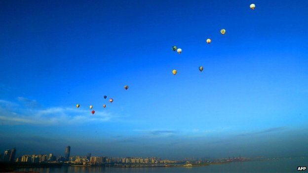 Hot air balloons fly across Qiongzhou Strait in Haikou, south China's Hainan province during the H1 China Hot Air Balloon Challenge on 18 June 2013