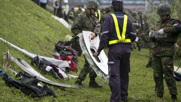 A rescue crew carries a window from a TransAsia Airways ATR 72-600 turboprop airplane that crashed into the Keelung River shortly after takeoff from Taipei Songshan airport on February 4, 2015 in Taipei, Taiwan