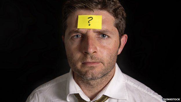 Man with Post-it note on his forehead, with question mark on it.
