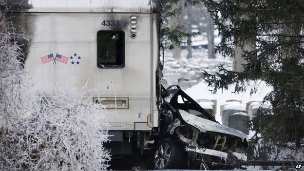 A sports utility vehicle remains crushed and burned at the front of a Metro North train Vahalla, New York 5 February 2015