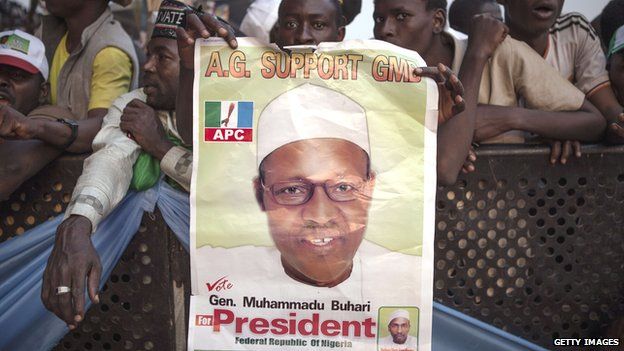 These supporters of the main Nigerian opposition All Progressive Congress (APC) party holds a campaing poster for Muhammadu Buhari, during a rally in Kaduna