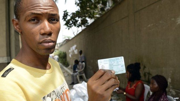 A voter shows his Permanent Voter's Card (PVC) after receiving it from officials of the Independent Electoral Commission in Lagos on 24 January 2015