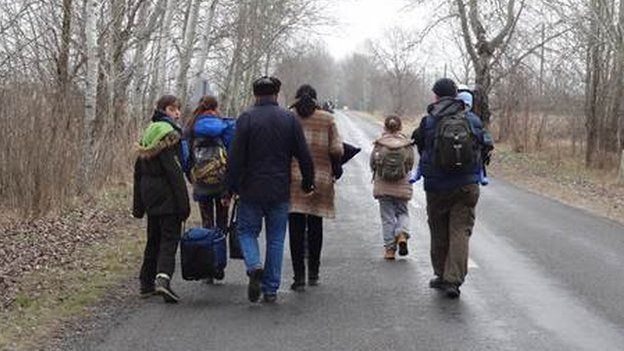 Migrants walk along the road in Asotthalom in Hungary