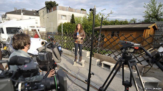 A Spanish journalist does a piece to camera in front of the house where Josef Fritzl lived, in Amstetten, in May 2008.