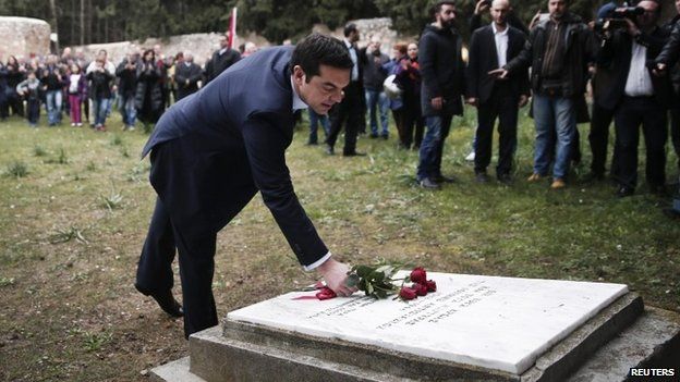 Greece's Prime Minister Alexis Tsipras leaves flowers on a monument at the Kessariani shooting range where hundreds of Greeks were executed by Nazi occupation forces