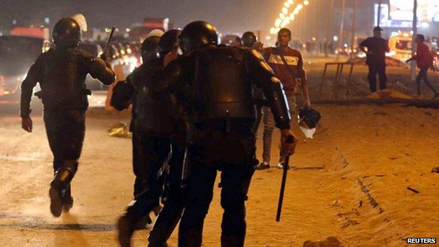 Policemen and soccer fans argue as fans attempt to enter a stadium to watch a match, on the outskirts of Cairo