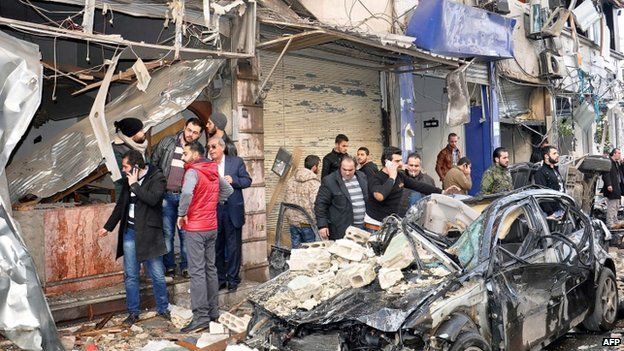 Residents standing among the wreckage after a bombing in Syria's city of Homs. Photo: 21 January 2015