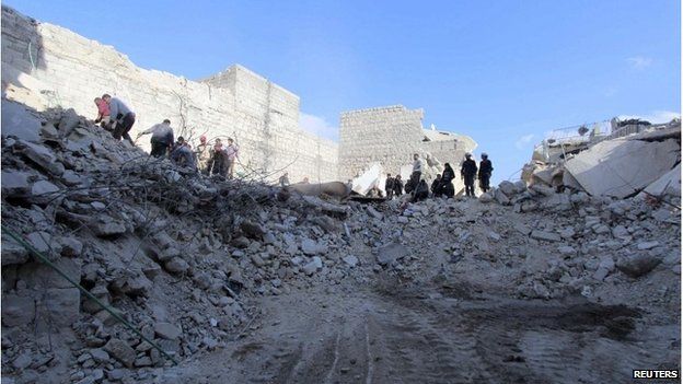 People search under rubble at a site hit by what activists said were barrel bombs in al-Halek neighbourhood of Aleppo, 1 February 2015.