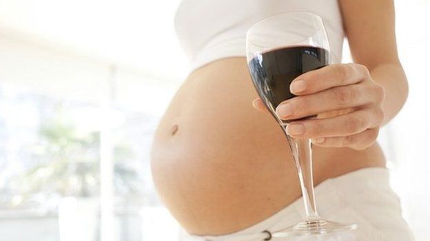 A pregnant woman with a glass of wine