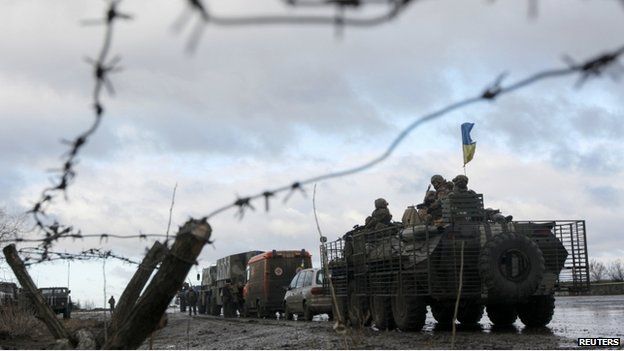 Ukrainian military convoy is pictured through a barbed wire fence at a military base in the town of Kramatorsk, eastern Ukraine, 24 December 2014