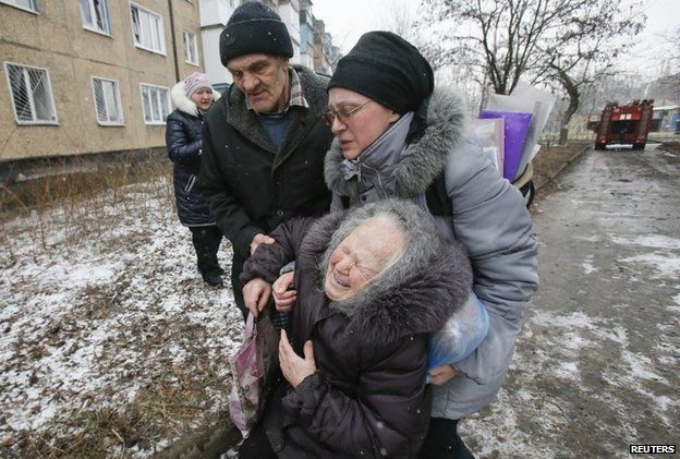 An elderly woman is comforted after her block in Donetsk is hit by shelling (9 Feb)