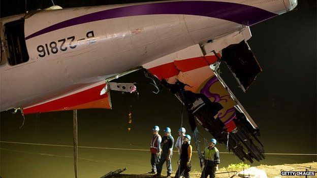 Rescuers lift the wreckage of the TransAsia ATR 72-600 oot of the Keelung river at New Taipei City on February 4, 2015