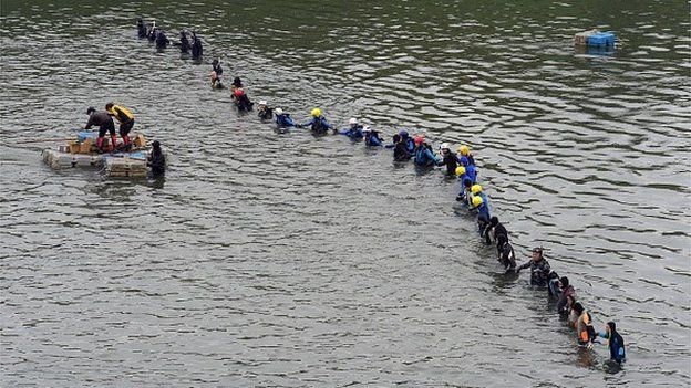 Rescuers and divers search for missing passengers at the crash site of the Transasia ATR 72-600 turboprop plane in the Keelung river in New Taipei City on February 6, 2015.