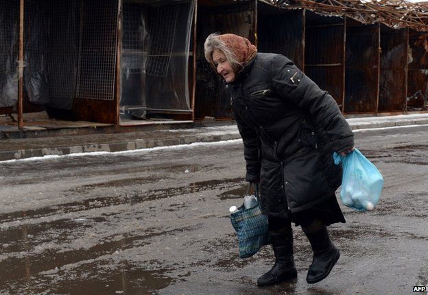 A woman passes a charred market in Donetsk city, 11 February
