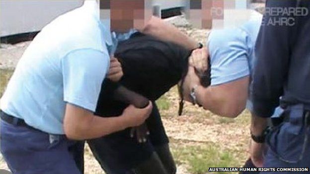 Young immigrant being manhandled in an Australian detention centre