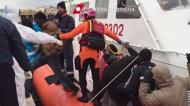 In this handout picture released by the Italian Coast Guards on February 10, 2015 migrants disembark from a boat from the Italian coast guards after a rescue operation off the coast of Lampedusa yesterday