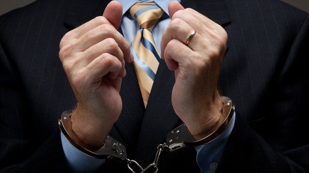 Man in suit wearing handcuffs