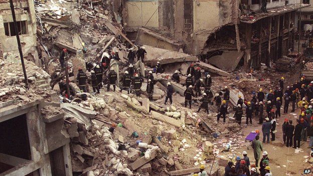 In this July 18, 1994 file photo, firefighters and rescue workers search through the rubble of the Argentine-Israeli Mutual Association community center, after a car bomb rocked the building in downtown Buenos Aires, Argentina