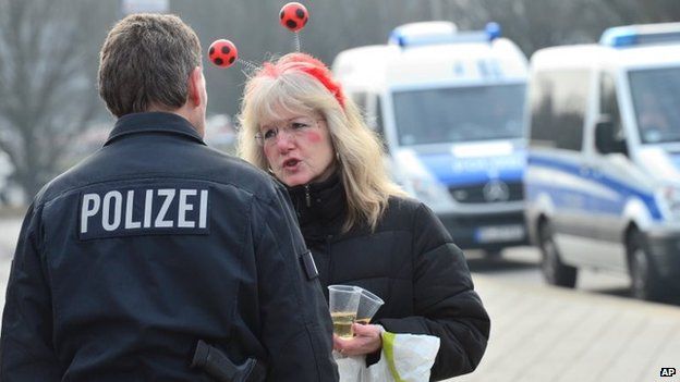 A woman dressed up for carnival talks to a policeman in Braunschweig, Germany, Sunday after the annual carnival procession was cancelled shortly before it was due to begin over fears of a terrorist attack