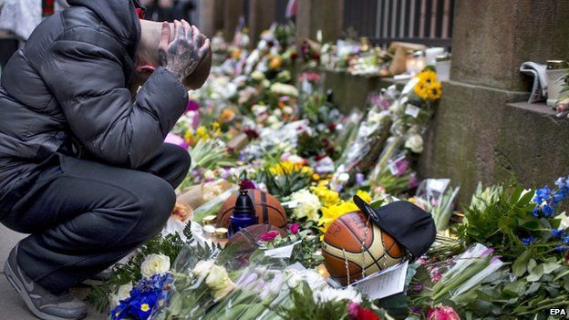 Man grieves next to flowers outside synagogue in Copenhagen 16/02/2015