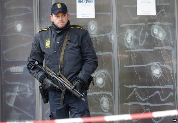 Офицер полиции стоит перед культурным центром, где боевик убил одного человека в Копенгагене, Дания. 16 февраля 2015 г.
