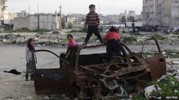 Syrian children play in the wreckage of a car in Aleppo's al-Myassar district (16 February 2015)