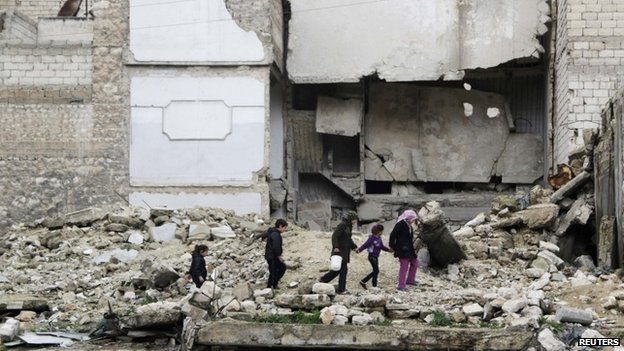 Children walk on the debris of a damaged building at al-Myassar neighborhood of Aleppo (16 February 2015)