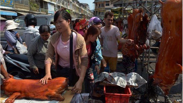 Woman packs a roasted pig at a new year fair in Phnom Penh, Cambodia