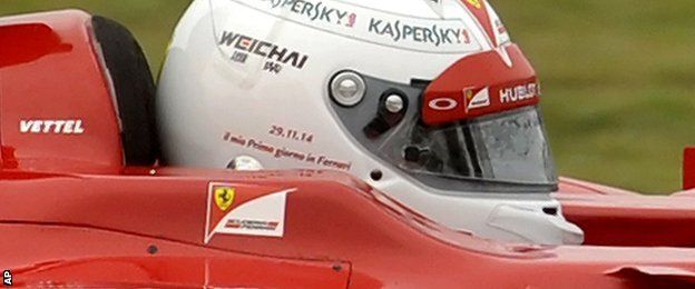 Sebastian Vettel with a helmet reading (in Italian): "My first day at Ferrari"