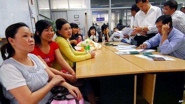 Thai immigration policemen (R) investigate Vietnamese women who were allegedly lured into becoming surrogate mothers at Immigration Police Bureau in Bangkok on February 24, 2011