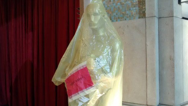A giants Oscars statue in a plastic wrapper